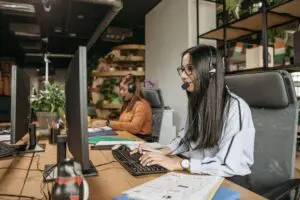 Women working at computers with headsets.